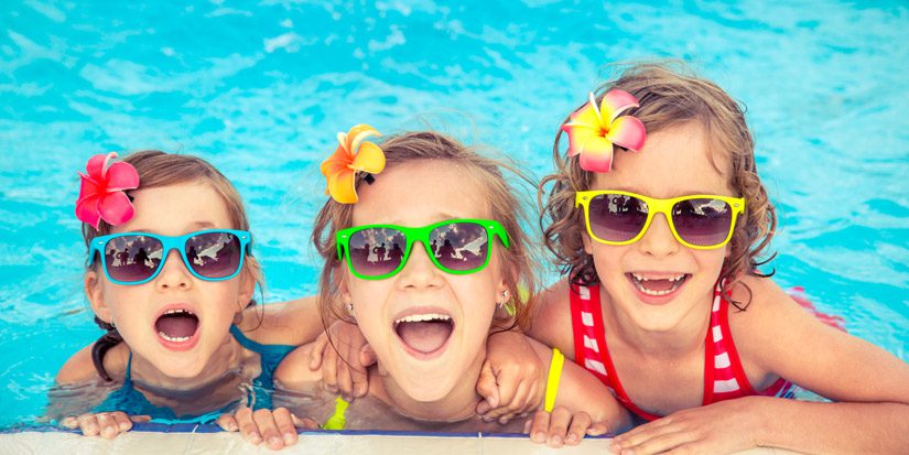 Three young happy girls in swimming pool
